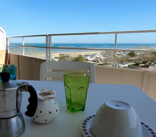 a table with a tea pot and a glass on a balcony at La terrazza sul mare in Cesenatico