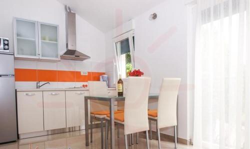 cocina con mesa de cristal y sillas blancas en Stari Dvori, en Trogir