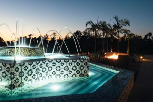 a swimming pool with a fountain at night at Park Hyatt Aviara in Carlsbad