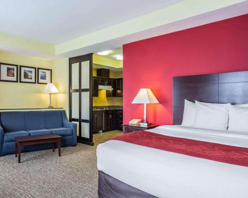 a hotel room with a large bed and a couch at Comfort Suites Rock Hill Manchester Meadows Area in Rock Hill