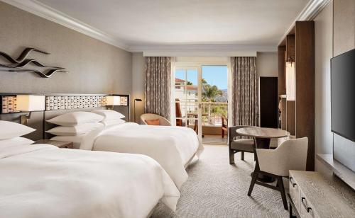 um quarto de hotel com quatro camas e uma televisão em Park Hyatt Aviara em Carlsbad