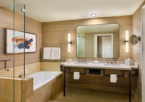 a bathroom with a tub and a sink and a mirror at Park Hyatt Aviara in Carlsbad