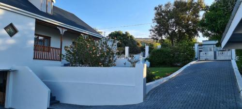 a white house with a white fence and a driveway at 7 on South in Bredasdorp