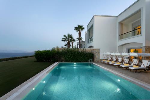 a villa with a swimming pool and a house at Xanadu Island in Akyarlar