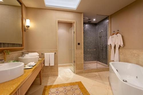 a bathroom with two sinks and a tub and a shower at Xanadu Island in Akyarlar