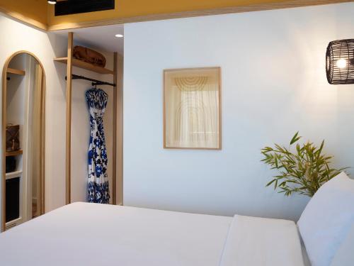a bedroom with a white bed and a plant at Brown Beach Evia Island, All Inclusive in Eretria, a member of Brown Hotels in Eretria