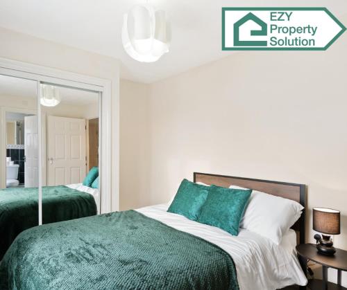 a bedroom with a bed with green sheets and a mirror at Stylish 2 bed Apt - Free Parking in Thamesmead