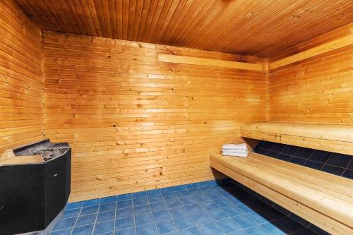 a sauna with wooden walls and blue tile floors at Hotel Malmkoping, BW Signature Collection in Malmköping