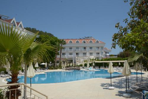 a resort with a swimming pool with chairs and umbrellas at MIRAMOR HOTEL & Spa - ULTRA ALL INCLUSIVE SELECTION in Kemer
