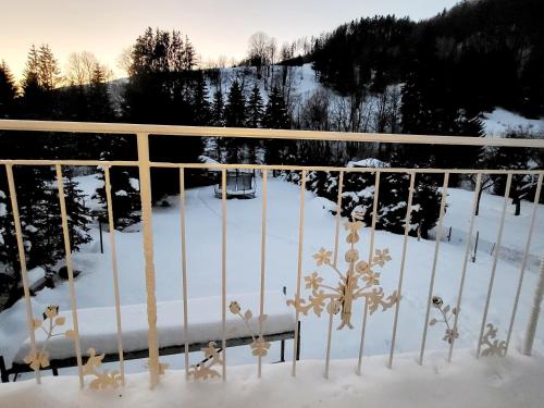 una cerca cubierta de nieve con un banco en ella en Apartmán provence Bystrá Chopok 2 en Bystrá