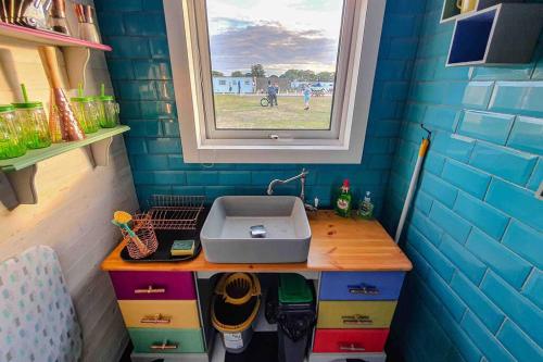 a small bathroom with a sink and a window at The Beach Hut in Scratby