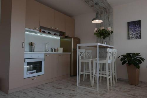 a kitchen with white stools and a table in a room at Charmful new flat with Hill view in Plovdiv