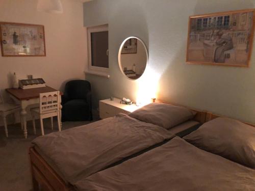 a bedroom with two beds and a table and a mirror at Stadtvilla-Apartment mit Parkblick und bester Verkehrsanbindung in Bremerhaven