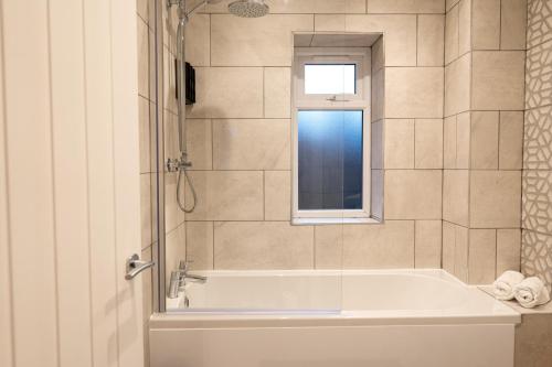 a bathroom with a bath tub and a window at The Mews, Amazing Newport 2 BR, Excellent location, Parking, Perfect for Contractors in Newport