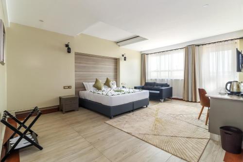 sala de estar con cama y sofá en Dallas Premiere Hotel en Kisii