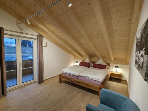 een slaapkamer met een bed, een stoel en een raam bij ApartSchön in Schwangau