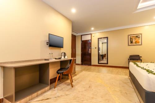 a hotel room with a desk and a bed at Dallas Premiere Hotel in Kisii
