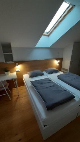 a bedroom with two large beds and a skylight at Fine Rooms Vipava in Vipava