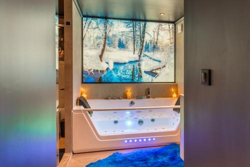 Televízia a/alebo spoločenská miestnosť v ubytovaní Balnéo, sauna, free champagne et de nombreuses surprises