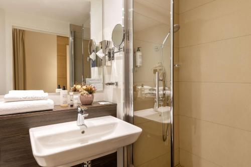 a bathroom with a sink and a shower at Best Western Royal Hotel Caen in Caen