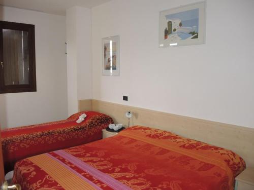 a hotel room with a bed and a bed sidx sidx sidx at Apartment with garden in residence with pool in Bibione