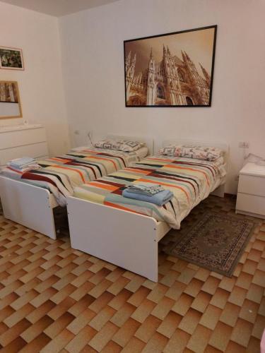 2 camas individuais num quarto com uma fotografia na parede em Flat in Milan 3 em Milão