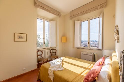 a bedroom with a bed and two windows at iFlat Spanish Steps at your Feet in Rome