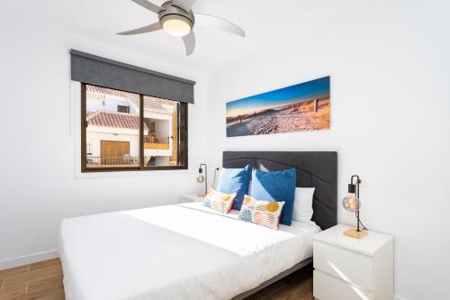 a bedroom with a white bed and a ceiling fan at Home2Book Cardón Sunny Design Home Los Cristianos in Arona