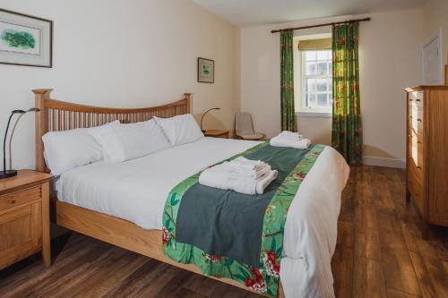 1 dormitorio con 1 cama con 2 toallas en Castle Cottage, a self-catering cottage full of character., en Amhuinnsuidhe