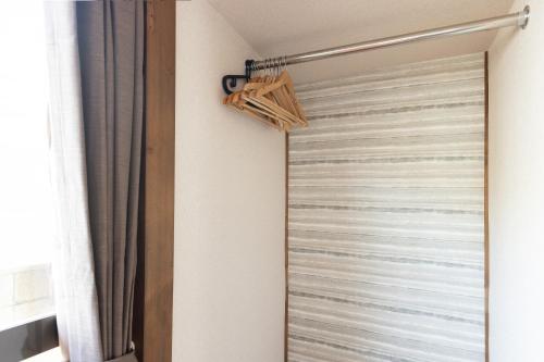 a shower door in a bathroom next to a window at The minpark in Dazaifu