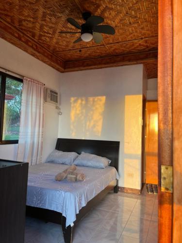 a bedroom with a bed with a ceiling fan at Virly’z Top View Resort 