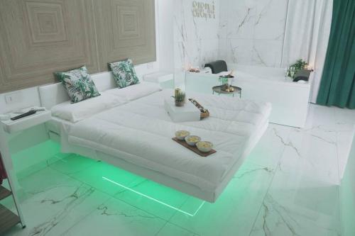 Sala de estar blanca con sofá blanco y mesa en Sisina Luxury Room Jacuzzi & Piscina, en Portici