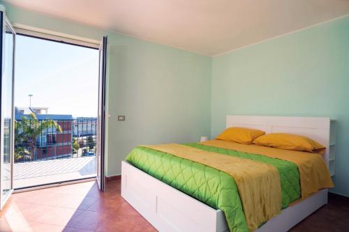 una camera con un letto e una grande finestra di VILLA PARADISO ACIREALE "con piscina in esclusiva o condivisa " ad Acireale