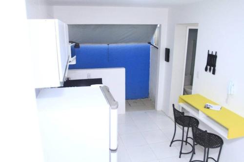 Zimmer mit 2 Stühlen und einem gelben Tisch in der Unterkunft Flat 106 próximo a orla in Aracaju