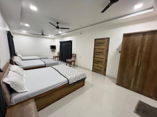 ein Schlafzimmer mit 2 Betten und einem Stuhl darin in der Unterkunft iIRA Stays-Sea Coast Farm in Alibag