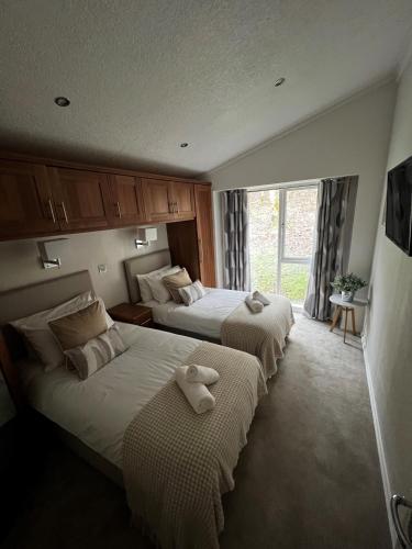 two beds in a hotel room with towels on them at Lowena Lodge in Troutbeck