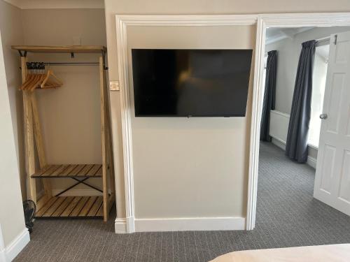 a sliding door with a flat screen tv in a room at Hotel Penwig in New Quay
