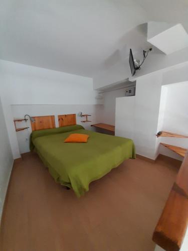 Un dormitorio con una cama verde en una habitación blanca en Costanerja, en Nerja