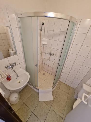 y baño con ducha, aseo y lavamanos. en Penzion Olympia en Banská Bystrica