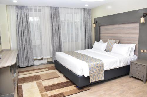 a hotel room with a bed and a television at Dallas Premiere Hotel in Kisii