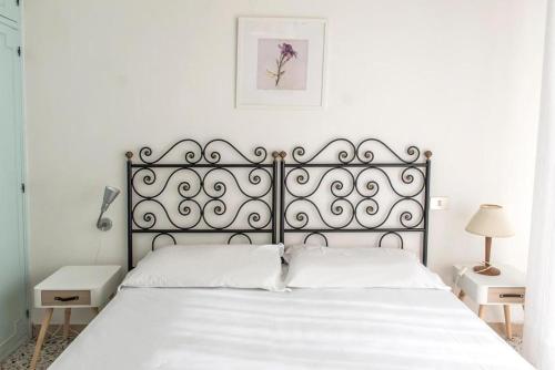 een slaapkamer met een groot bed met witte lakens bij N122 - Numana, villa singola con giardino e vista mare in Numana