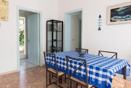 een eetkamer met een blauw en wit geruite tafel en stoelen bij N122 - Numana, villa singola con giardino e vista mare in Numana