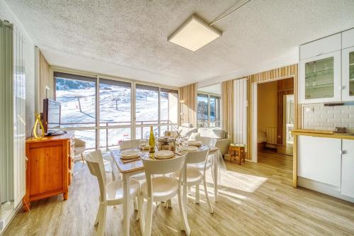 une cuisine et une salle à manger avec une table et des chaises dans l'établissement Le Baikonour, à Villarembert