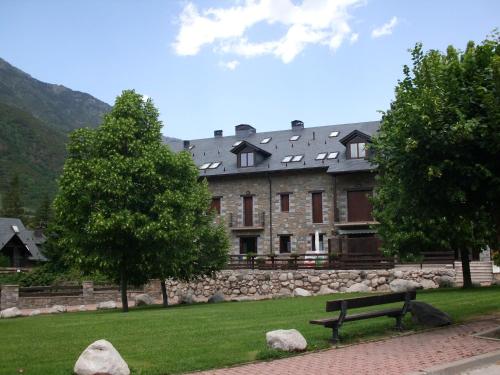 un gran edificio de piedra con un banco en un parque en Apartamento Nevados 2620 en Anciles