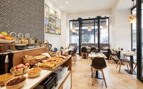 un restaurant avec un buffet de plats et de tables dans l'établissement Hotel Petit Lafayette, à Paris