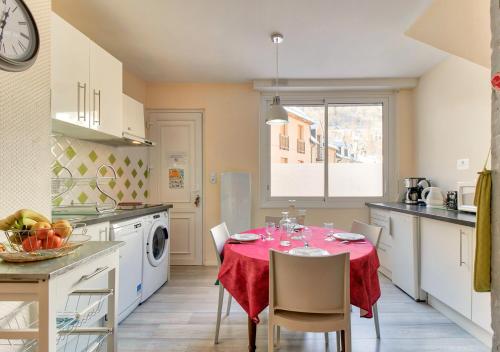 une cuisine avec une table et un chiffon rouge dans l'établissement La Pauze, à Cauterets