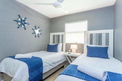2 camas en un dormitorio con azul y blanco en Chaka's Cove, en Ballito