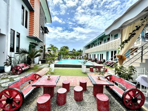 a courtyard with red tables and a swimming pool at Little Rock Cebu in Mactan