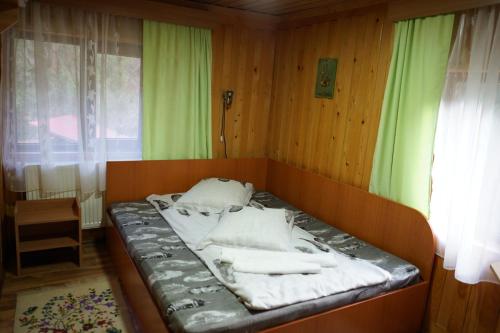ein kleines Bett in einem Zimmer mit Fenster in der Unterkunft Cabana Suprema Armonie in Dâmbovicioara