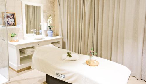 a hospital room with a bed and a mirror at Thalazur Arcachon in Arcachon